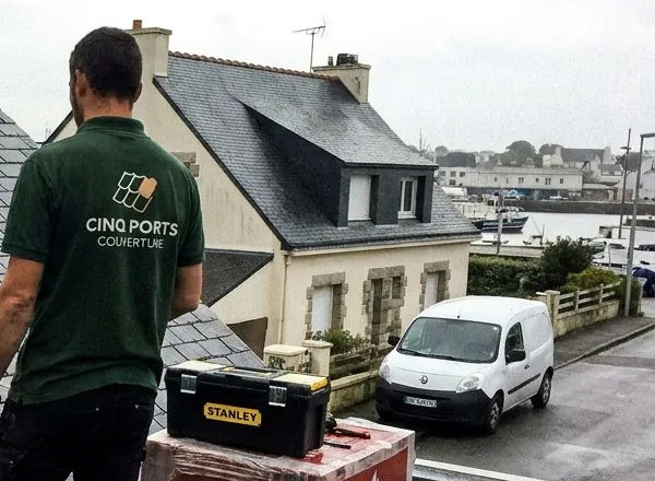 Couvreur Cinq Ports Couverture observant les toits d'ardoise d'un quartier de Lorient avant une réfection